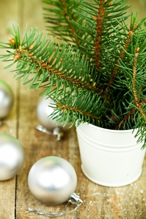 bucket with christmas fir tree and white decorations on a wooden boardの写真素材