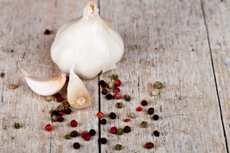 fresh garlic and peppercorns on rustic wooden background の写真素材