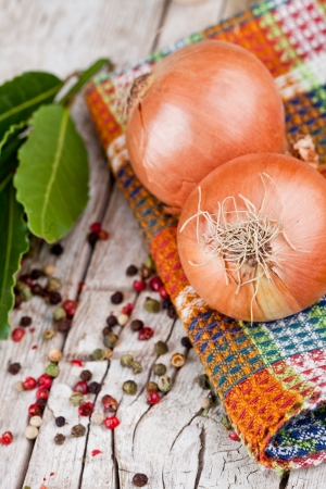 fresh onions, peppercorns and bay leaves closeup on rustic wooden tableの写真素材