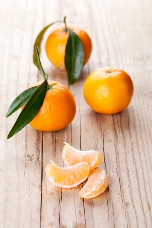 fresh tangerines with leaves on a wooden tableの写真素材