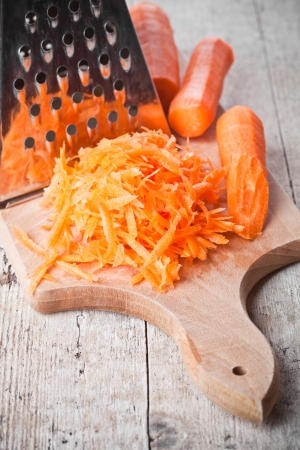 metal grater and carrot closeup on cutting boardの写真素材