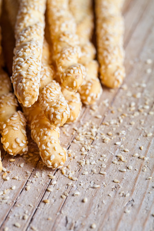 bread sticks grissini with sesame seeds closeup on rustic wooden backgroundの写真素材