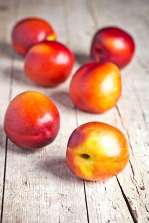 fresh nectarines on rustic wooden boardの写真素材