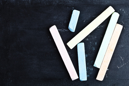 four pieces of chalk over a blackboard