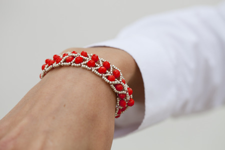 Stylish red bead bracelet on female hand - closeupの写真素材