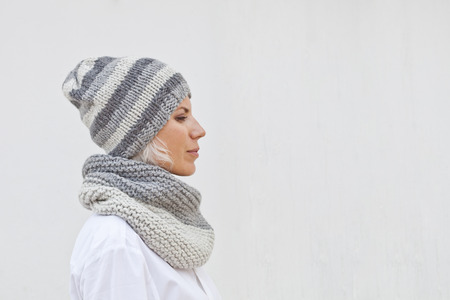 Pretty young woman in warm grey knitted hat and snood.の写真素材