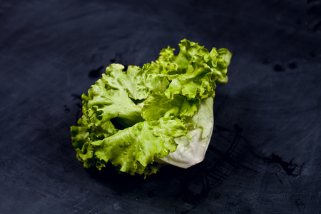 Fresh green lettuce salad on black background.の写真素材
