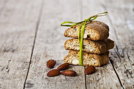 Fresh Italian cookies cantuccini stack and almond nuts on ructic wooden table background. Sweet food with copy space.の写真素材