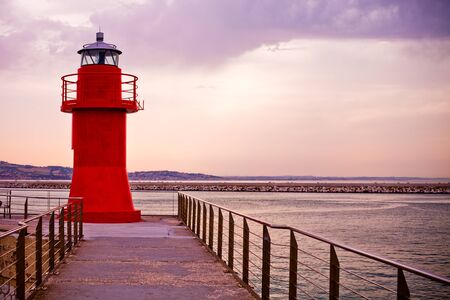 Red lighthouse of Ancona, Italy, on a sunny evening in summer, sunset.の写真素材