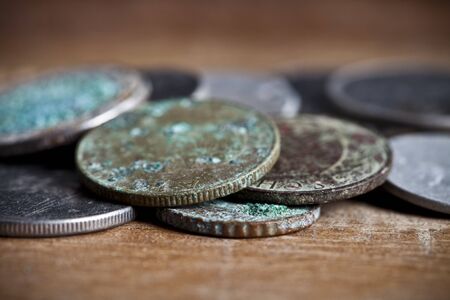 Pile of different ancient copper coins with patina ccloseup on rustic wooden table background.の写真素材