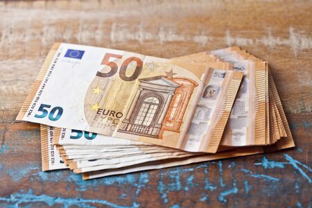 Pile of fifty euro banknotes. 50â¬ currency notes stacked on wooden table background.の写真素材