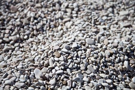 Abstract background with grey and white peable stones on Adriatic beach.