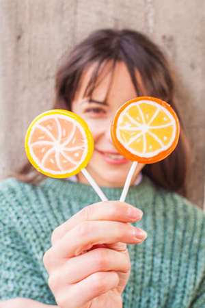 Portrait of pretty young happy woman posing with sweet lollipops.の写真素材