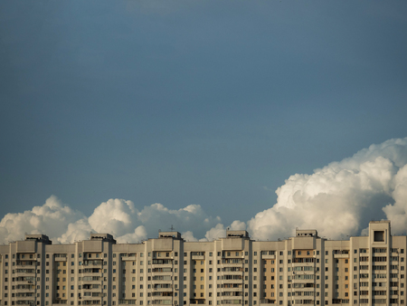 Big clouds over building, blue sky and big clouds, building on a background of clouds, building on sky backgroundの写真素材