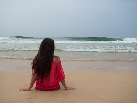 Portrait of a woman on a tropical beach wearing pink dressの写真素材