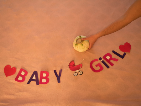 Inscription child girl lined on bed. Symbol of pregnancy cabbage.の写真素材