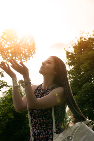 A girl with a huge dandelion, which is made of garbage.の写真素材