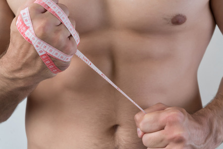 The guy struggles with excess weight. The meter is wound on a fist.の写真素材