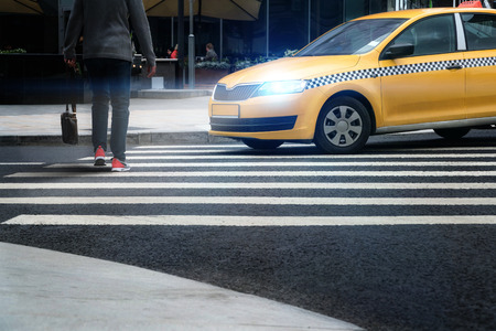A taxi at a pedestrian crossing misses a person.の写真素材