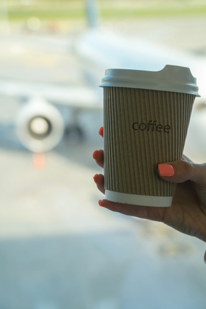 Cup of coffee in airport's business lounge with aircraft.の写真素材