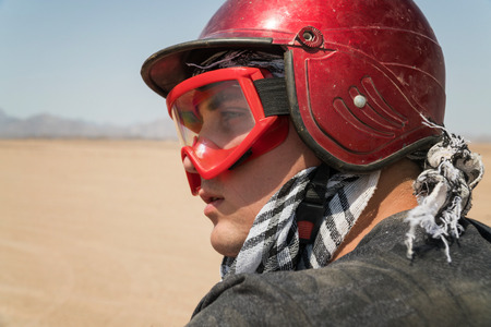 Young guy during desert excursion by quad - Man in helmet and adventure clothes in exotic scenarios - Concept of activity holiday, freedom and adventure.の写真素材