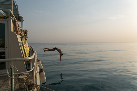 Man jump into the water from the yacht.の写真素材