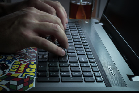 Men's hands are typing on the laptop's keyboard.の写真素材