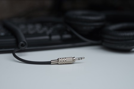 Metal plug of professional headphones on white table.の写真素材