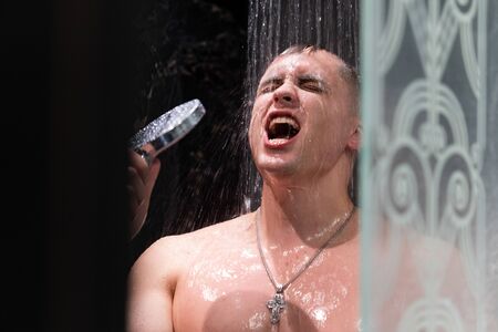 The guy sings in the shower. Shower with dark wallsの写真素材