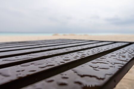 Wooden chair on the beach after a rainの写真素材