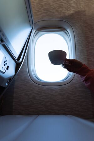 Womans hand with a coffee in airplaneの写真素材