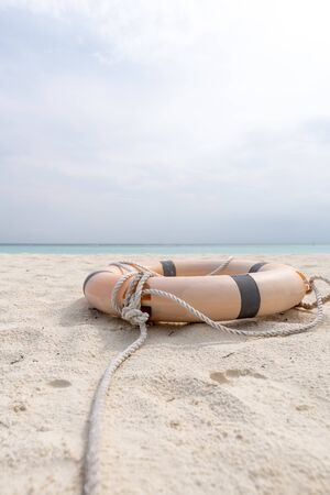 Lifebuoy and rope lie on the beach of a tropical beach.の写真素材