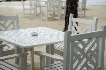 White table restaurant on the beach. The rainy season has begun.