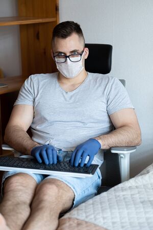 The quarantined guy works remotely from home. Communication, people and freelance work conceptの写真素材