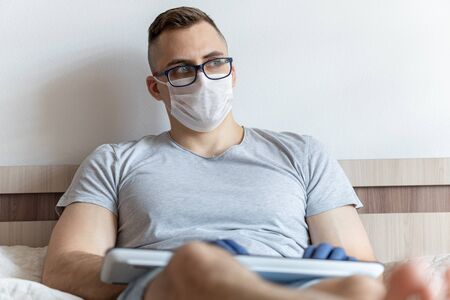 The quarantined guy works remotely from home. Communication, people and freelance work conceptの写真素材