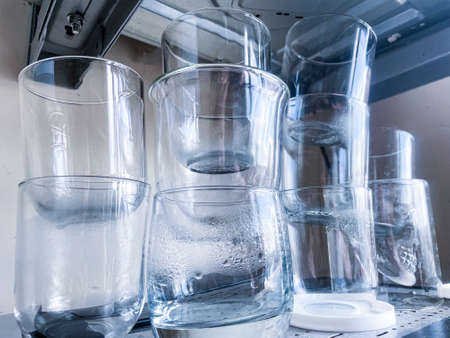 Drinking glasses with water drops put one on another