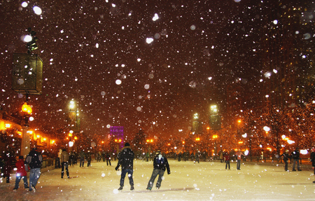 People enjoying ice skating during snowy night in Chicago.の写真素材