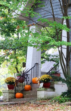 Main entrance stair and porch of the old house decorated for autumn holidays season. Halloween concept. Fall background. Vertical composition.の写真素材