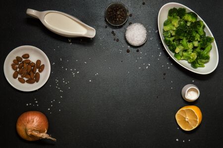 Flat lay, top view. Flat lay, top view. Ingredients for broccoli cream soup: broccoli, cream, lemon, salt, pepper, almond, onion, flour. Black background. Copy space. Still life.の写真素材