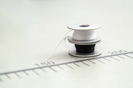 Close up, macro. Sewing spools with black and white threads. White background.の写真素材