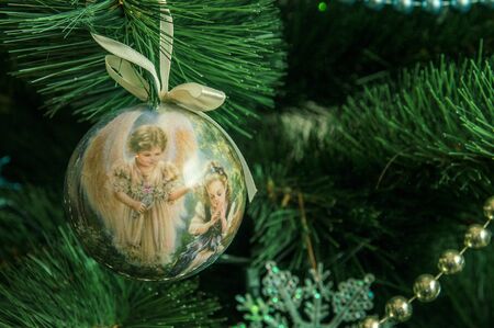 Close up, macro. Christmas tree decoration in the shape of a ball decorated with angels. Copy space.の写真素材