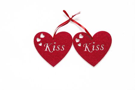 Close up, macro. Greeting Card on Valentine's Day. Two red felt hearts with an inscription kiss. Objects are located in the center, isolated on white background. Copy space.の写真素材