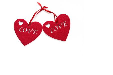Close up. Greeting Card on Valentine's Day. Two red felt hearts with an inscription love. Objects are located on the left, isolated on white background. Copy space.の写真素材