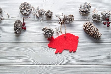 Top view, flat lay. Christmas wooden background. Rustic stylized garland with fir cones and Pink Pig - symbol of the Chinese New Year 2019.の写真素材