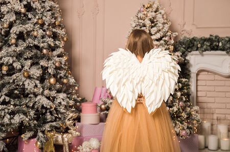 Close up. Christmas location. View from the back of a child in the image of a Christmas angel.の写真素材