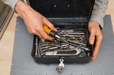 Close up. Home renovation tool kit, furniture setting. The repairman is holding an open toolbar.の写真素材