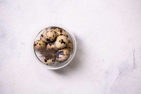 Close up. A bunch of brown quail eggs in a transparent bowl. Farm product. Preparing for Easter. Copy space, top view, flat lay.の写真素材