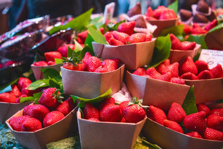 Close up. Eco-friendly cardboard boxes with strawberries for tourists at a Spanish market Mercado de...