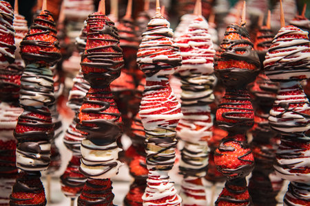 Close up, macro. Strawberries on skewers covered in chocolate. Barcelona market. Spanish street...