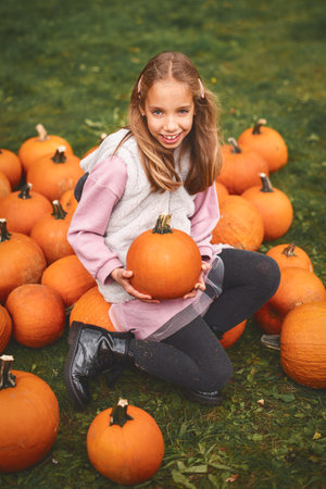 Close up. Vertical oriented. Portrait of a child girl on Pumpkin farm.の写真素材